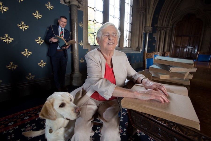  Pictured: Joan Muir with her guide dog Elma, and Allen Paterson, president of The Irvine Burns Club at The University of Glasgow. Photo credit: Martin Shields