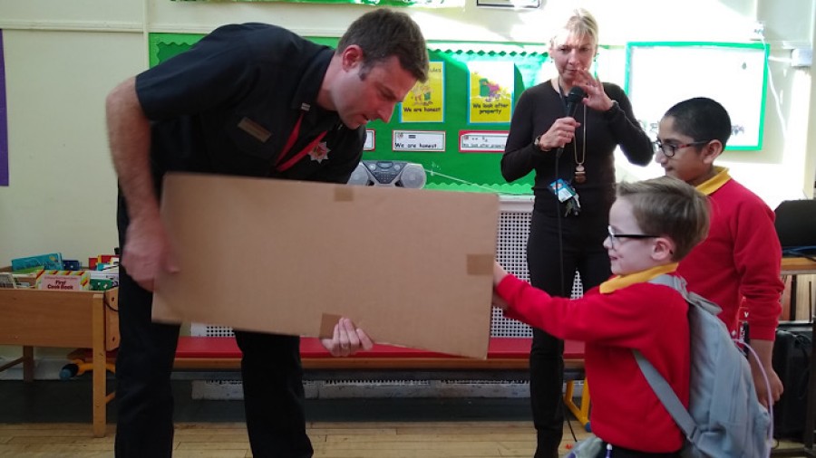  Firefighters hand ove a cheque for £3,000 to pupils at Kelbourne Park School