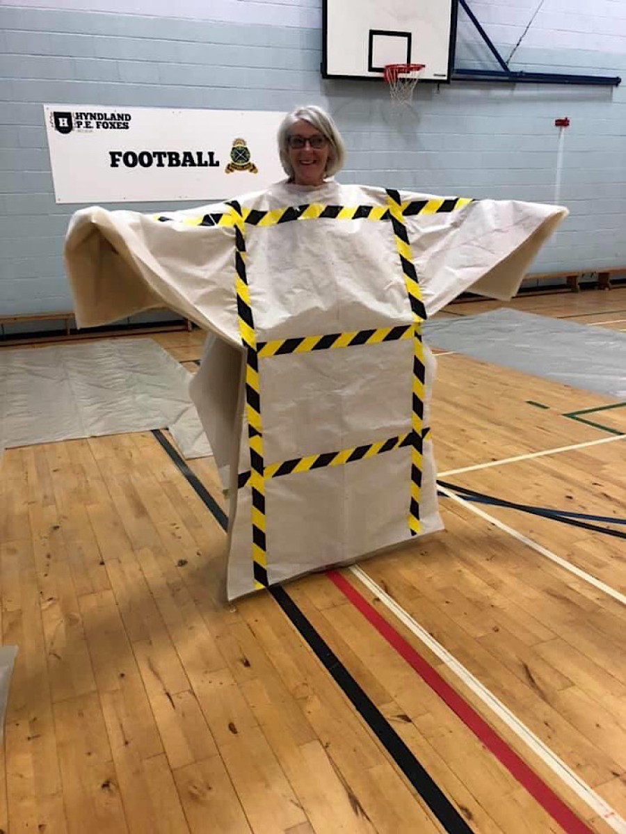  Teacher Shirley McIlroy models an unfastened plastic gown at the school. Photo: Kay Muir