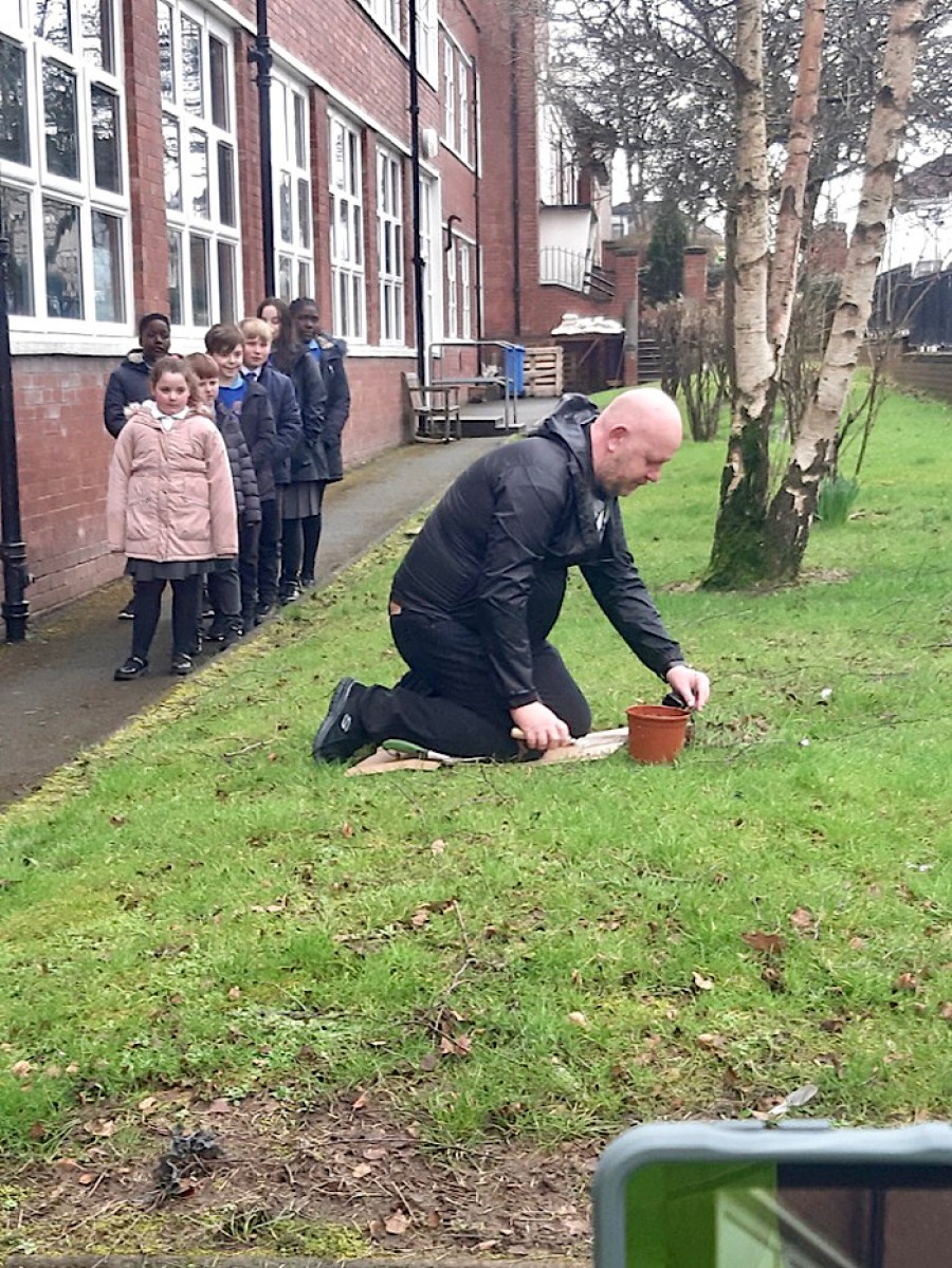 Neil McLintock plants an oak tree at the school.